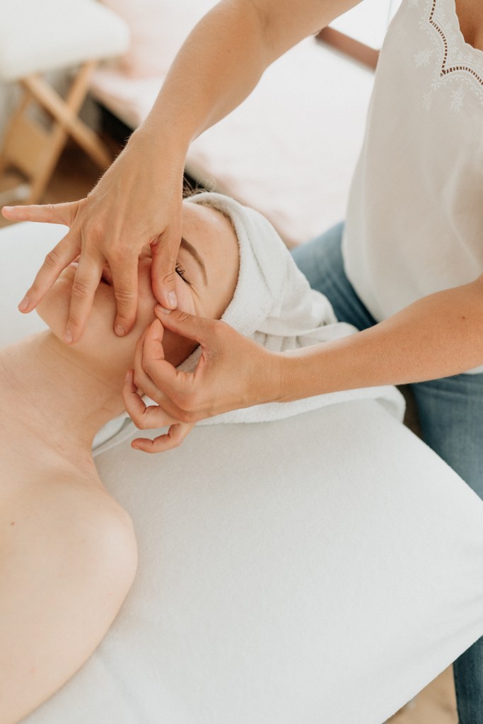 Femme prenant soin de visage à travers le soin kobido