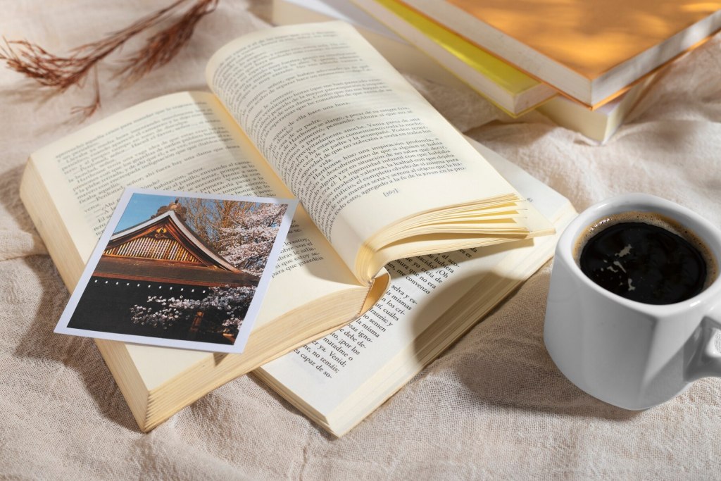 Deux livres sur lesquels se trouvent une photo et une tasse de café à côté